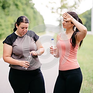 Women drink water and rest after outdoor jogging