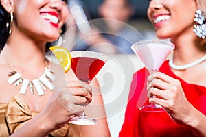 Women drinking cocktails in fancy bar