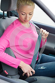 Women driver fastening her seat belt