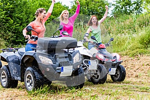 Women driving off-road with quad bike or ATV