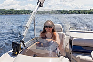 Women driving a pontoon boat on a lake