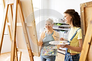 Women with easels and palettes at art school