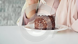 women eating chocolate cake on white table