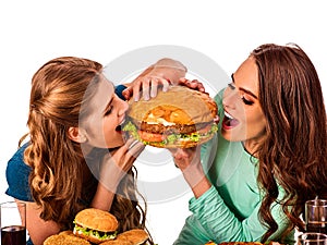 Women eating fast food. Gils eat hamburger with ham .