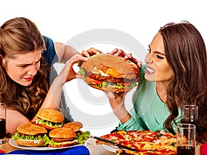 Women eating fast food. Gils eat hamburger with ham .