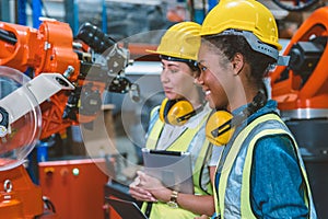 Women engineer worker working team helping together at work in modern advance machine factory