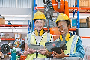 Women engineer worker working team training together at work in modern advanced robot welding machine factory