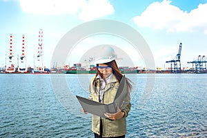 The women engineer working with container Cargo freight ship in shipyard