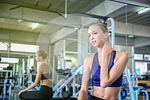 Women exercise already painful. Young caucasian female having pain in her neck while workout at the gym. Woman feeling strong pain