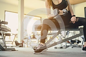 Women exercise by dumbbells at the indoor gym for good health at sunset.