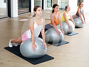 Women exercising with ball during group pilates class