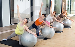Women exercising with ball during group pilates class