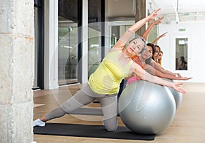 Women exercising with ball during group pilates class