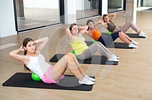 Women exercising with ball during group pilates class