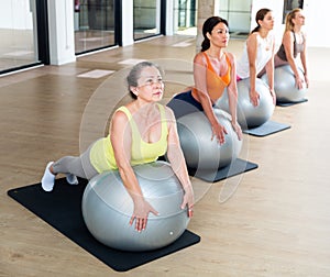 Women exercising with ball during group pilates class