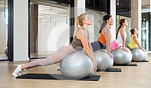 Women exercising with ball during group pilates class