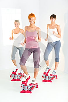 Women exercising on stepping machine