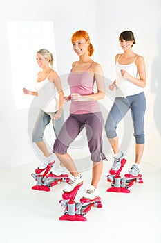 Women exercising on stepping machine