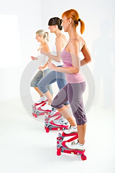 Women exercising on stepping machine