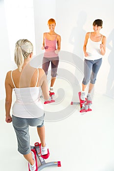 Women exercising on stepping machine