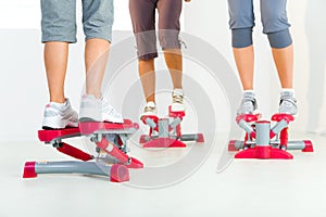 Women exercising on stepping machine