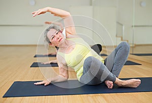 Women exercising during yoga class in fitness center - vakrasana pose photo