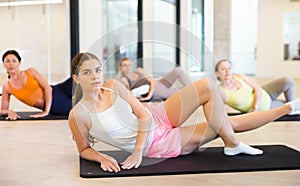 Women exercising during yoga class in modern fitness center
