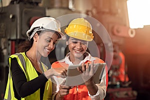 Women in factory engineer mix race working together using tablet happy smile