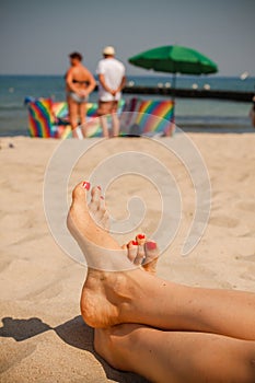 Women feet on the beach.
