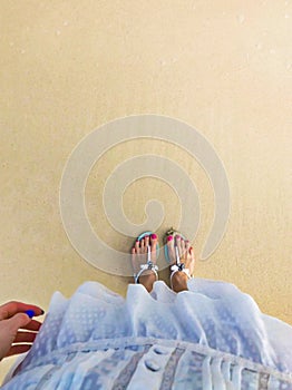 Women feet on the sea sand. Top view.