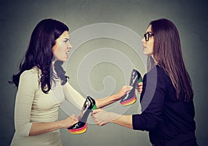 Women fighting tearing pulling apart shoes