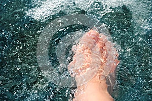 Women foot, refreshing and hardening in a mountain brook