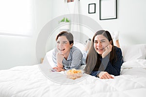 Women friends with a beaming smile and watching tv