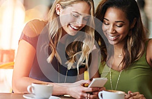 Women, friends and coffee shop with cellphone or funny meme with laughing, social media or restaurant. Female people photo