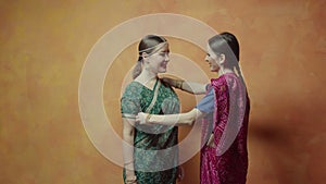 Women friends fitting hindu sari and communicating