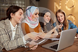 Women. Friends Meeting In Cafe. Four Smiling Girls With Laptop And Tablet Working At Bistro.