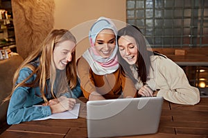 Women. Friends Meeting In Cafe. Group Of Three Young Girls With Laptop Having Fun In Bistro.