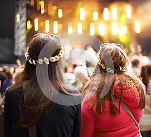 Women, friends and music festival in audience at outdoor concert, listening to live band. Female people, stage and