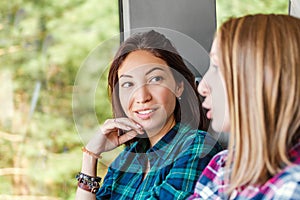 Women Friends talk and laugh while traveling by train or bus