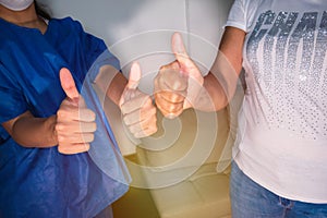 Women giving a victorious thumb to show their success and motivation, a close look at their raised hands