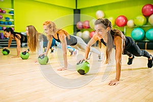 Women group with balls doing push up exercise