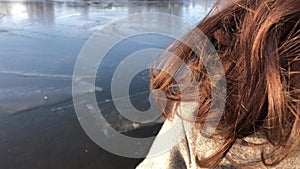 Women hair close-up in the outdoor against the background of a frozen river