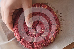 women hand creaking red velvet cookies photo