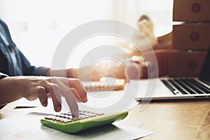 Women hand doing finances and calculate on desk about cost at home office