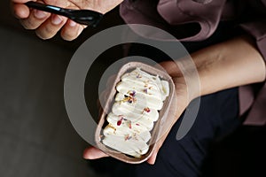 women hand eating a cake top view