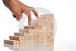 Women hand finger walk on stacked wooden block