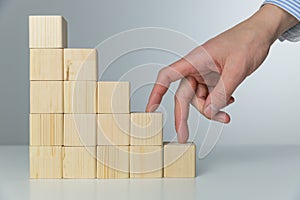 Women hand finger walk on stacked wooden block like stairs. Business development and growth concept