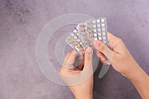 women hand golding birth control pills on black background