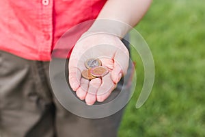 Women hand holding coins, the concept of business, natural green background in summer day