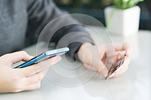 Women hand holding credit card and using cell phone for online shopping